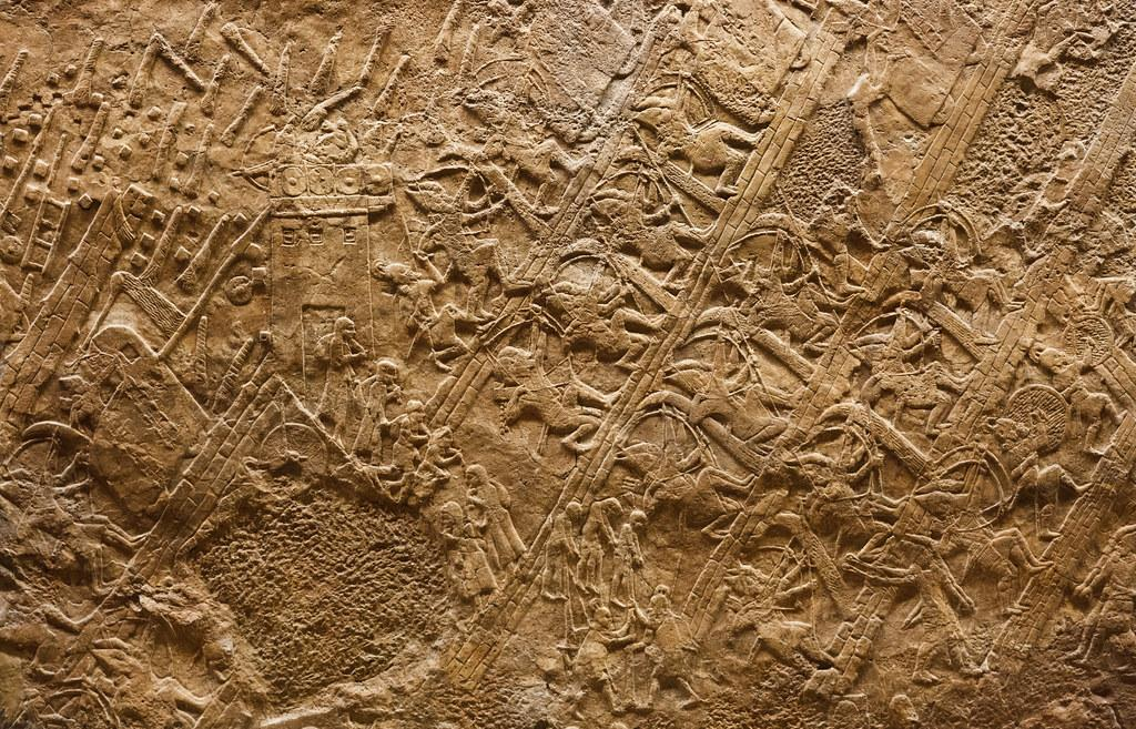 A carved stone panel from the Lachish Reliefs, showing Assyrian soldiers storming the walls of Lachish up a siege ramp.