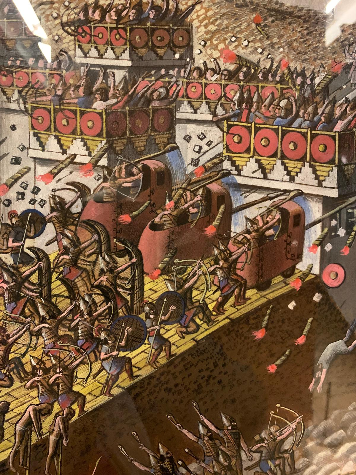 A painted reconstruction of the Assyrian siege of Lachish, with archers and battering rams on a ramp beneath the city walls.
